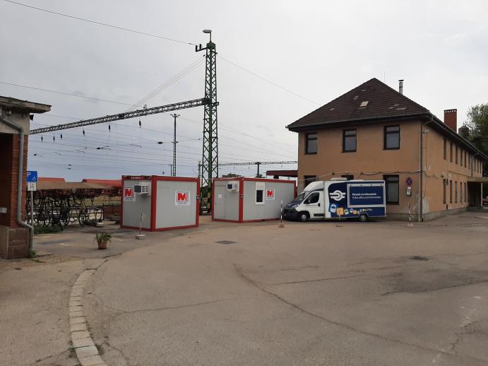 Várpalota vasútállomás felvételi épülete és az állomás területén elhelyezett ideiglenes konténerek.